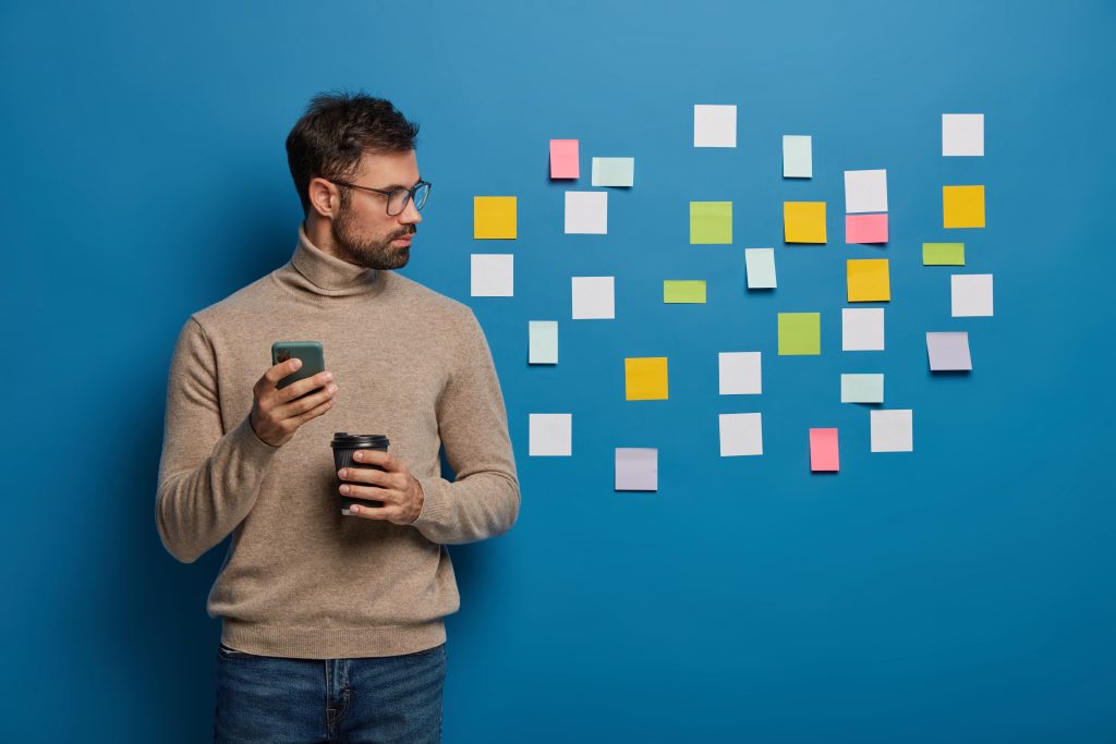 bearded-male-organizing-his-tasks-using-sticky-notes (1)